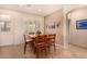 Cozy dining area with a square wooden table, six chairs, and natural light from a nearby window at 10903 E Ocaso Ave, Mesa, AZ 85212