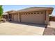 Spacious three-car garage with desert landscaping along the driveway at 10903 E Ocaso Ave, Mesa, AZ 85212