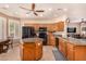 Spacious kitchen with a central island, wooden cabinetry, granite counters, and modern appliances at 10903 E Ocaso Ave, Mesa, AZ 85212