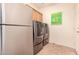 Laundry area featuring side-by-side stainless steel washer and dryer, and overhead cabinets at 10903 E Ocaso Ave, Mesa, AZ 85212