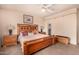Comfortable main bedroom with a wooden bed frame, ceiling fan, and side tables with lamps at 10903 E Ocaso Ave, Mesa, AZ 85212
