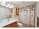 Bathroom with a framed mirror, wood cabinet, and decorative shower curtain at 11113 W Cameo Dr, Sun City, AZ 85351
