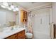Bathroom featuring a shower/tub combo with a decorative shower curtain and wood cabinet at 11113 W Cameo Dr, Sun City, AZ 85351