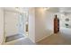 Bright entryway with tiled floor, carpeted hallway, decorative lighting, and a view of the bathroom at 11113 W Cameo Dr, Sun City, AZ 85351