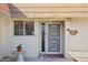 Close-up of the front door with security screen, adjacent window, and decorative bird wall hanging at 11113 W Cameo Dr, Sun City, AZ 85351