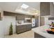 Well-lit kitchen with tile floors, a skylight, dark wood cabinets, and white countertops and breakfast bar at 11113 W Cameo Dr, Sun City, AZ 85351