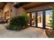 Back patio with stone details, beautiful plants, and large sliding glass doors at 11240 E Apache Vistas Dr, Scottsdale, AZ 85262