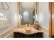 Stylish bathroom with unique stone sink, decorative mirror, and modern lighting fixtures at 11240 E Apache Vistas Dr, Scottsdale, AZ 85262