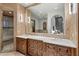 Bathroom featuring double sinks, walk-in shower, and natural stone walls at 11240 E Apache Vistas Dr, Scottsdale, AZ 85262