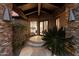 Exterior view of a primary bedroom through the house's stone framed entryway at 11240 E Apache Vistas Dr, Scottsdale, AZ 85262