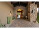 Beautiful foyer with stone archway, brick flooring, and desert landscaping at 11240 E Apache Vistas Dr, Scottsdale, AZ 85262