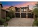Three-car garage with a balcony above, adding architectural interest to this home at 11240 E Apache Vistas Dr, Scottsdale, AZ 85262
