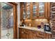 Kitchen nook featuring custom wood cabinetry, granite countertop, and a designer glass paneled doorway at 11240 E Apache Vistas Dr, Scottsdale, AZ 85262