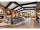 Open living room with stone accents, wood beam ceilings, fireplace, and large sliding glass doors at 11240 E Apache Vistas Dr, Scottsdale, AZ 85262