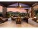 Covered outdoor patio with comfortable seating, stone pillars, and views of the golf course at 11240 E Apache Vistas Dr, Scottsdale, AZ 85262
