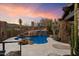 Lush backyard with a rock waterfall feature spilling into a sparkling blue pool at 11240 E Apache Vistas Dr, Scottsdale, AZ 85262