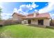 Manicured backyard features a large grassy area, block fence, and covered patio at 11243 E Jenan Dr, Scottsdale, AZ 85259