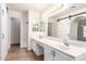 Bathroom featuring double sinks, a large vanity, and a barn door style mirror at 11243 E Jenan Dr, Scottsdale, AZ 85259