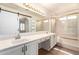 Bright bathroom with double sinks, a long vanity, and a barn door style shower at 11243 E Jenan Dr, Scottsdale, AZ 85259