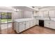 Bright kitchen features white cabinets, black dishwasher, breakfast bar, and glass sliding doors to backyard at 11243 E Jenan Dr, Scottsdale, AZ 85259
