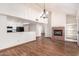 Open-concept living room featuring a brick fireplace and hardwood floors at 11243 E Jenan Dr, Scottsdale, AZ 85259