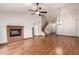Bright living room features a brick fireplace, ceiling fan, wood floors, and stairs to the second floor at 11243 E Jenan Dr, Scottsdale, AZ 85259