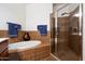 Well-maintained bathroom featuring tiled walls, a soaking tub, and a glass-enclosed shower at 11640 N Tatum Blvd # 3091, Phoenix, AZ 85028