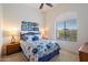 Bright bedroom with a large window, ceiling fan and a blue and white patterned comforter at 11640 N Tatum Blvd # 3091, Phoenix, AZ 85028