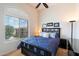 Comfortable bedroom featuring a window with blinds, ceiling fan and blue and white bedding at 11640 N Tatum Blvd # 3091, Phoenix, AZ 85028