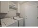 Functional laundry room featuring a washer, dryer, and convenient upper cabinets for storage at 11752 N 135Th Pl, Scottsdale, AZ 85259