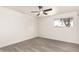 Bright, minimalist bedroom with a ceiling fan, large window, and light wood-look flooring at 11842 N 30Th Dr, Phoenix, AZ 85029