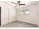 This bedroom features a ceiling fan, a window with a view of the neighborhood, and a closet with sliding doors at 11842 N 30Th Dr, Phoenix, AZ 85029