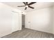 This bedroom features a ceiling fan, wood-look flooring, and a closet with bi-fold doors at 11842 N 30Th Dr, Phoenix, AZ 85029