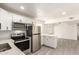 Modern kitchen with stainless steel appliances, white cabinets, and a view into the living area at 11842 N 30Th Dr, Phoenix, AZ 85029