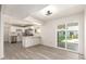 Bright living room and kitchen with gray-toned flooring and neutral walls; slider to back yard at 11842 N 30Th Dr, Phoenix, AZ 85029
