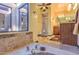 Bright bathroom featuring tub with tile surround, skylight, and vanity with sink at 12646 N 80Th Pl, Scottsdale, AZ 85260