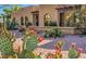 View of the property with blooming cacti set in desert landscaping with gravel and other desert vegetation at 12646 N 80Th Pl, Scottsdale, AZ 85260
