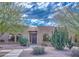 Charming tan home featuring desert landscaping with cacti, arched windows, and a stone pathway leading to the front door at 12646 N 80Th Pl, Scottsdale, AZ 85260