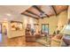 Spacious living room with wood-beam ceiling, a cozy fireplace, and views of the backyard at 12646 N 80Th Pl, Scottsdale, AZ 85260