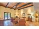 Bright living room featuring a wood-beam ceiling, fireplace, and access to the outdoor space at 12646 N 80Th Pl, Scottsdale, AZ 85260