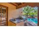 Outdoor kitchen area featuring stone counters, built in gas grill, and access to the pool at 12646 N 80Th Pl, Scottsdale, AZ 85260