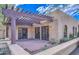 Covered patio area with brick flooring, a wooden pergola, double doors, and exterior lighting fixtures at 12646 N 80Th Pl, Scottsdale, AZ 85260