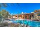 Backyard oasis featuring a sparkling pool, covered patio, and lush desert landscaping at 12646 N 80Th Pl, Scottsdale, AZ 85260