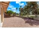 Landscaped backyard with gravel, decorative fence, and mature trees on a sunny day at 14207 W Kiowa Trl, Surprise, AZ 85374