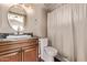 Cozy bathroom with wood cabinets, granite countertop, and shower with white curtain at 14207 W Kiowa Trl, Surprise, AZ 85374