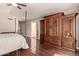 Bedroom with hardwood floors, a built-in wardrobe, and a sliding glass door at 14207 W Kiowa Trl, Surprise, AZ 85374