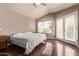 Bedroom with ceiling fan, hardwood floors, a window, and a sliding glass door at 14207 W Kiowa Trl, Surprise, AZ 85374
