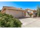 Single story home showcasing the front two car garage and tile roof and the private gated courtyard at 14207 W Kiowa Trl, Surprise, AZ 85374