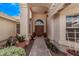 Inviting front entrance with double doors, mature landscaping, and stylish architectural details at 14207 W Kiowa Trl, Surprise, AZ 85374
