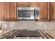 Kitchen features a stainless steel microwave over an electric stove and granite countertops at 14207 W Kiowa Trl, Surprise, AZ 85374